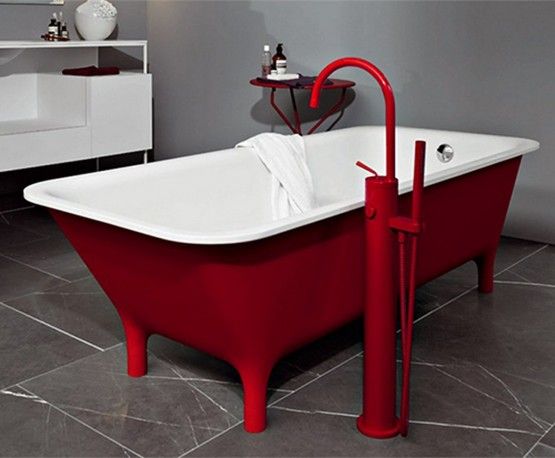 czerwona wanna wolnostojąca z czerwoną wylewką w zestawie w szarej łazience z białymi meblami