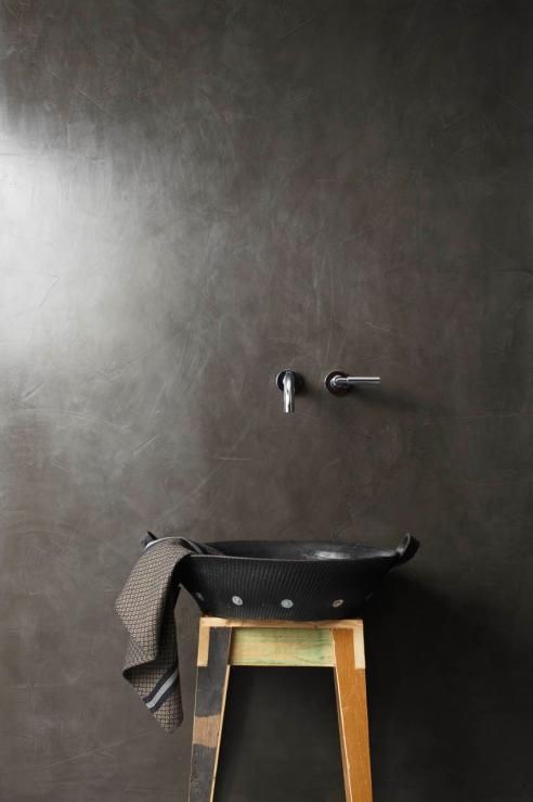 minimalistyczna czarna łazienka z czarną umywalką na drewnianym
