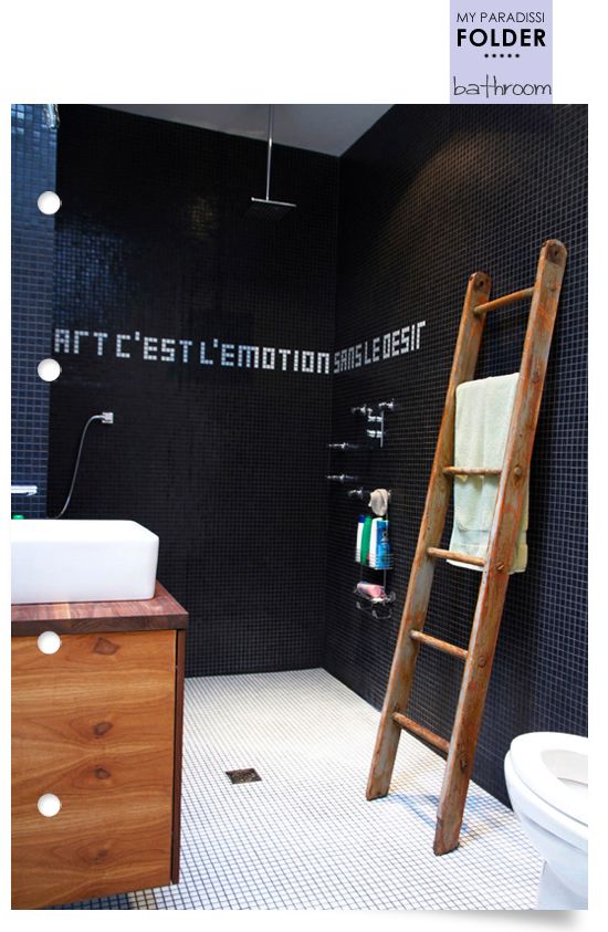 czarna łazienka w połaczeniu z drewnianymi dodatkami w postaci drabinki i szafeczki ocieplają jej wizerunek