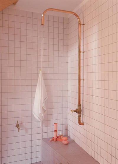 Zewnętrzna instalacja w łazience prysznica w formie grubej miedzianej rurki bez deszczownicy