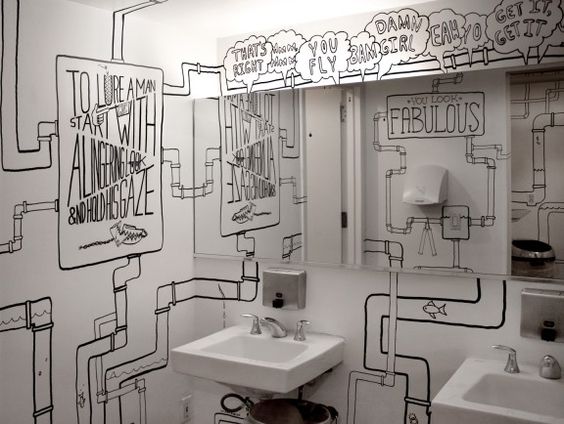 łazienka w restauracji udekorowana rysunkami na ścianach