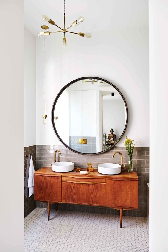 wielkie okrągłe lustro przy dwóch okrągłych umywalkach, przez swą wielkość jest mocnym akcentem łazienki
